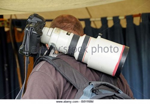 man-carrying-large-white-lens-on-his-shoulder-b8yr8m.jpg